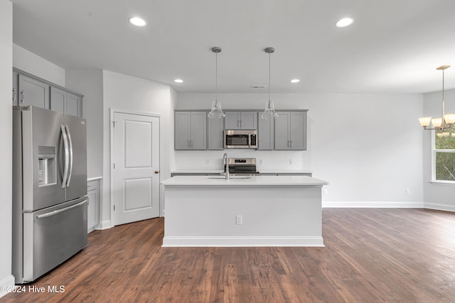 kitchen with dark wood-type flooring, sink, decorative light fixtures, and stainless steel appliances