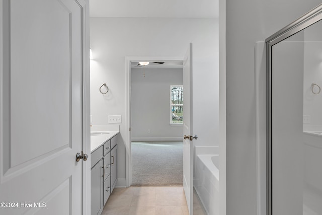 bathroom with a bath, vanity, and tile patterned flooring