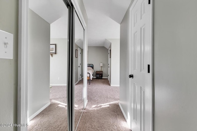 hall featuring lofted ceiling and carpet floors