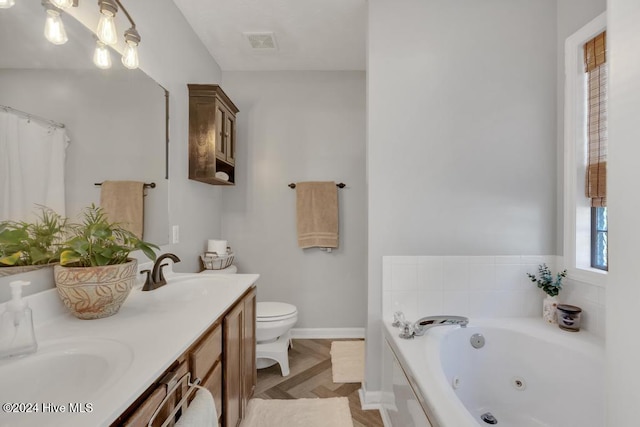 bathroom with toilet, vanity, and a bathtub