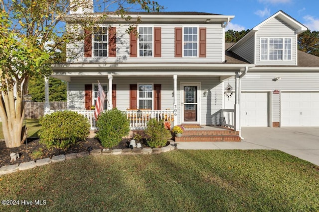 view of front of home with a front yard, covered porch, and a garage