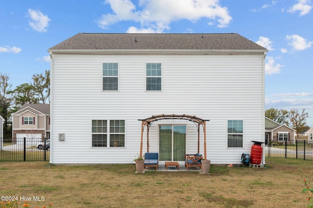 rear view of house with a patio and a lawn