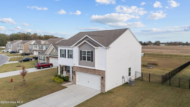 view of front of house with a garage, central AC unit, and a front yard