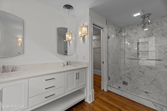 bathroom featuring a shower with door, vanity, and wood-type flooring