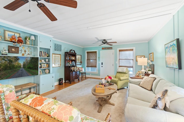 living room with ceiling fan, light wood-type flooring, and crown molding