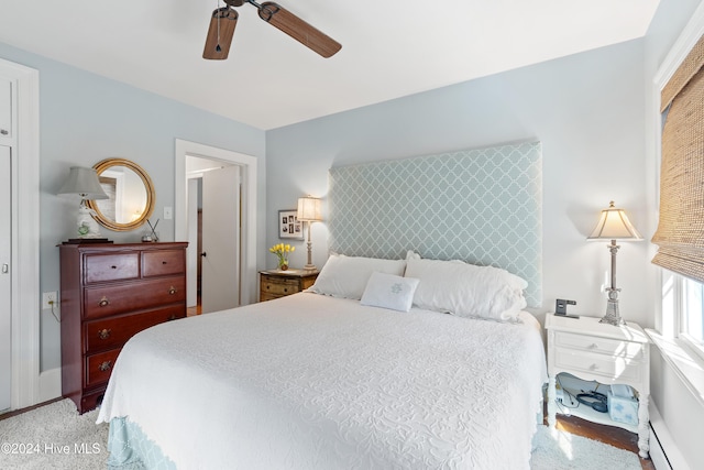 carpeted bedroom with baseboard heating and ceiling fan