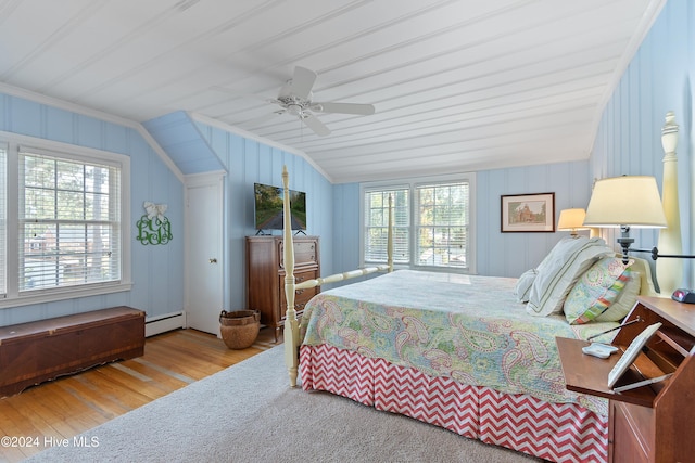 bedroom featuring hardwood / wood-style flooring, ceiling fan, multiple windows, and vaulted ceiling