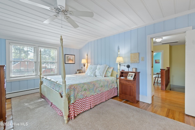 bedroom featuring ceiling fan, wood-type flooring, baseboard heating, and crown molding