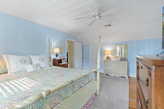 carpeted bedroom with ceiling fan and vaulted ceiling