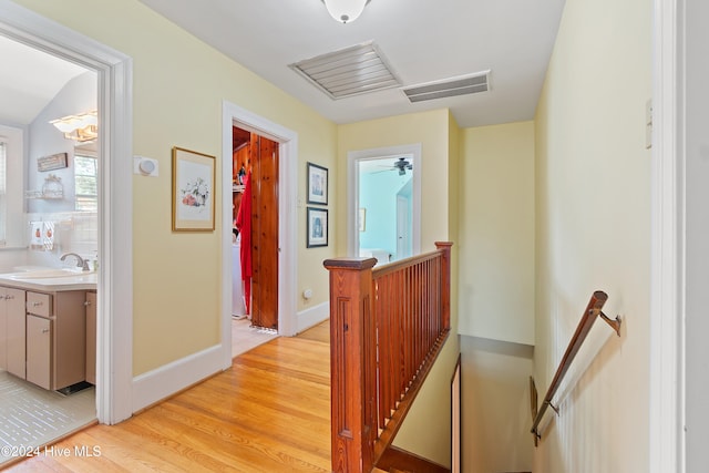 corridor featuring light hardwood / wood-style floors and sink