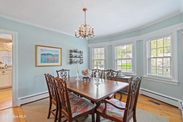 dining room featuring an inviting chandelier, crown molding, light hardwood / wood-style flooring, and a baseboard heating unit