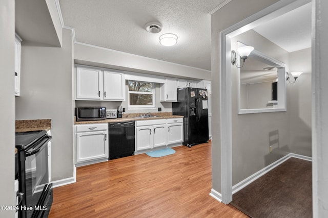 kitchen featuring white cabinetry, light hardwood / wood-style flooring, a textured ceiling, black appliances, and ornamental molding