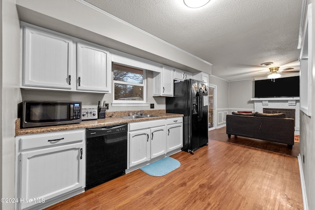 kitchen featuring ceiling fan, white cabinets, black appliances, and light wood-type flooring