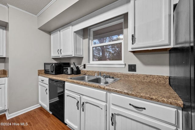 kitchen with black appliances, sink, dark hardwood / wood-style floors, ornamental molding, and white cabinetry