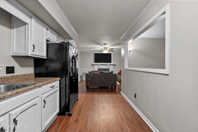 kitchen featuring white cabinetry, ceiling fan, a textured ceiling, and hardwood / wood-style flooring