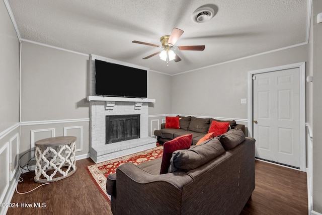 living room featuring dark hardwood / wood-style flooring, a textured ceiling, and a brick fireplace