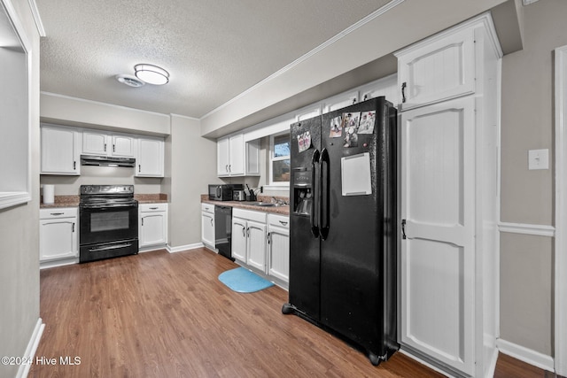 kitchen featuring white cabinets, light hardwood / wood-style flooring, and black appliances