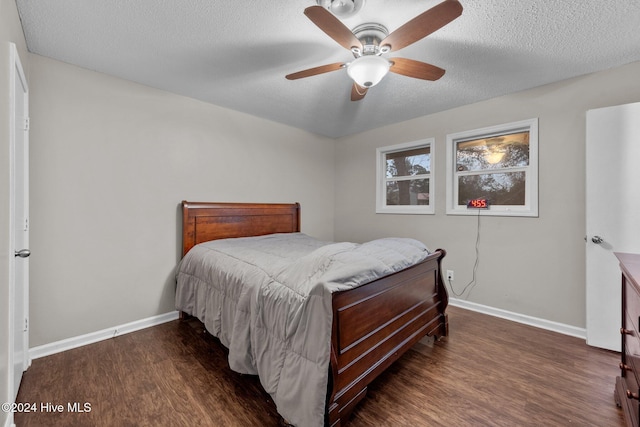 bedroom with ceiling fan, dark hardwood / wood-style floors, and a textured ceiling