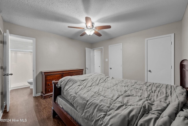 bedroom featuring ensuite bath, ceiling fan, dark wood-type flooring, and a textured ceiling