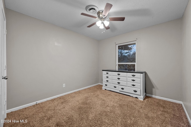 unfurnished bedroom featuring ceiling fan, carpet floors, and a textured ceiling