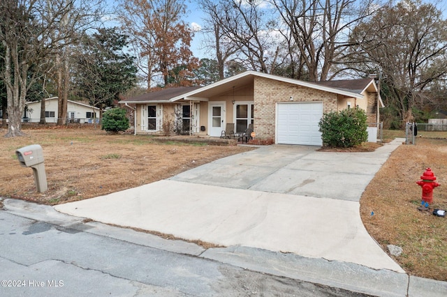 ranch-style house featuring a garage and a front lawn