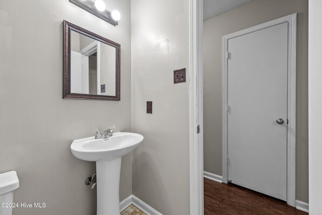 bathroom featuring hardwood / wood-style flooring, sink, and a textured ceiling