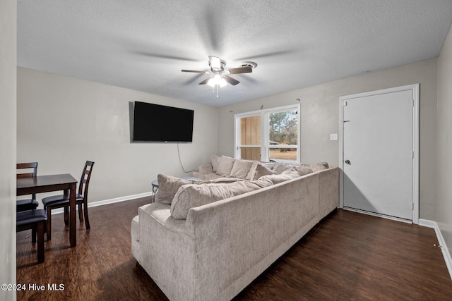 living room with ceiling fan, dark hardwood / wood-style flooring, and a textured ceiling