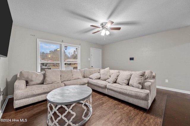 living room featuring a textured ceiling, ceiling fan, and dark wood-type flooring