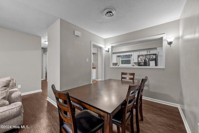 dining area featuring a textured ceiling and dark hardwood / wood-style flooring