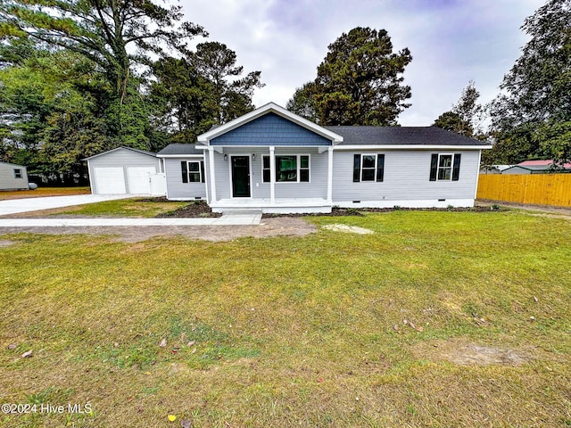 view of front facade with an outbuilding, a garage, a front lawn, and covered porch