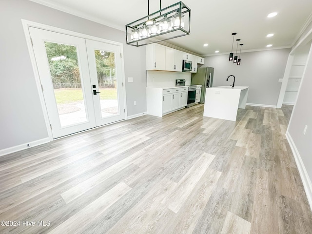 kitchen featuring light hardwood / wood-style floors, hanging light fixtures, a kitchen island with sink, white cabinetry, and appliances with stainless steel finishes