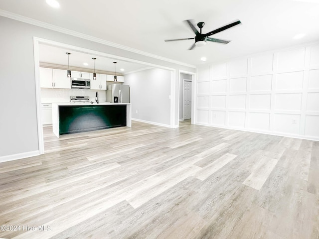 unfurnished living room with ornamental molding, light wood-type flooring, sink, and ceiling fan