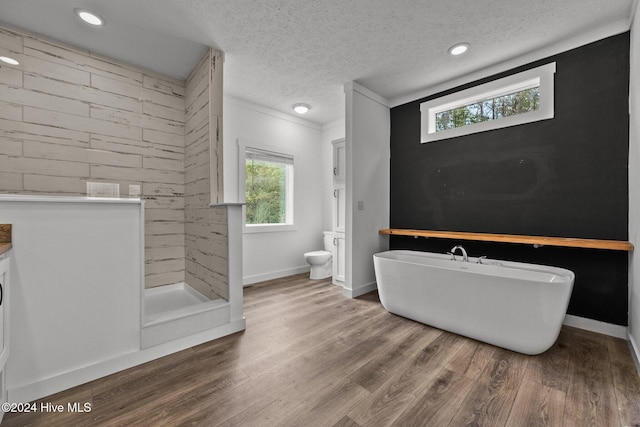 full bathroom with toilet, a textured ceiling, and a wealth of natural light