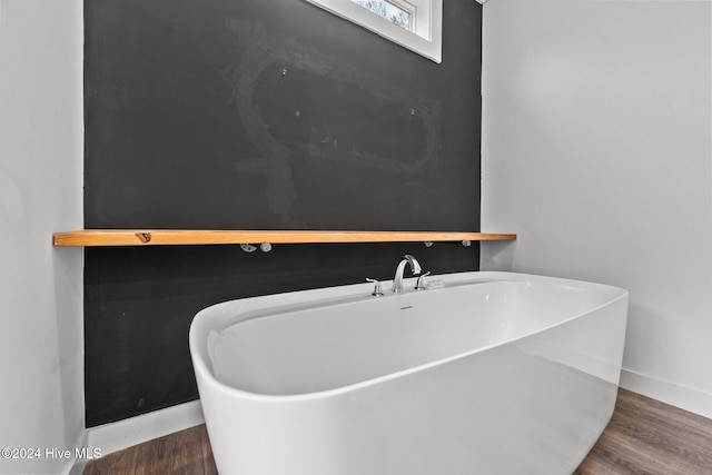 bathroom with hardwood / wood-style floors and a bathtub