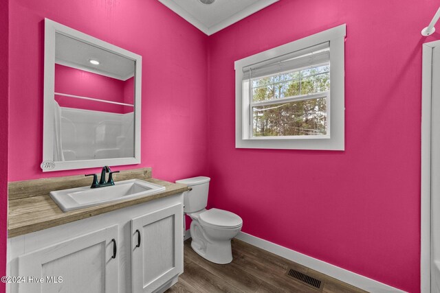 bathroom featuring toilet, vanity, wood-type flooring, and walk in shower