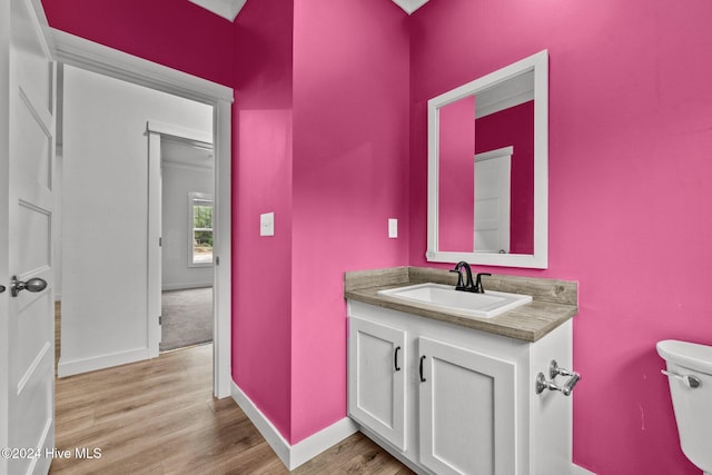 bathroom featuring wood-type flooring, vanity, and toilet