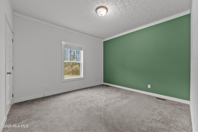 empty room with carpet floors, a textured ceiling, and ornamental molding