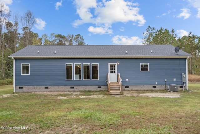 rear view of house featuring a lawn and cooling unit