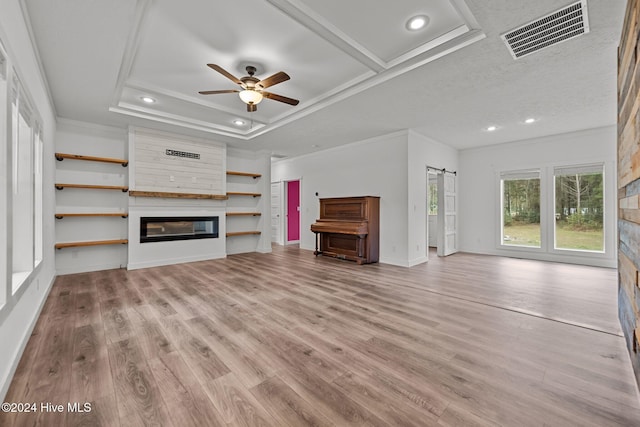 unfurnished living room with a large fireplace, light wood-type flooring, and ornamental molding