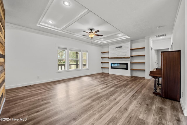 unfurnished living room featuring hardwood / wood-style flooring, ceiling fan, a large fireplace, and ornamental molding