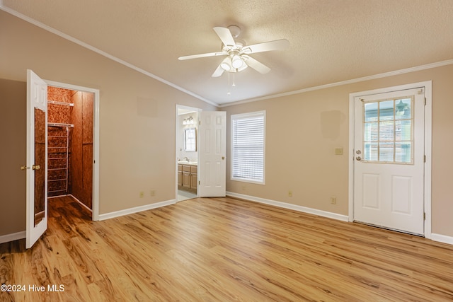 interior space featuring ensuite bath, crown molding, light hardwood / wood-style flooring, and a textured ceiling