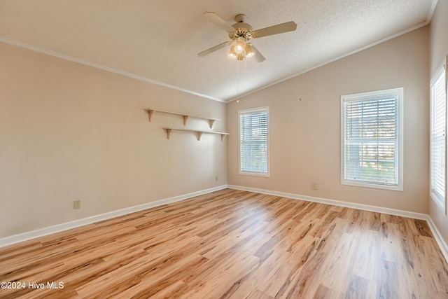 spare room with light hardwood / wood-style floors, ornamental molding, and vaulted ceiling