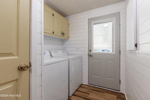 clothes washing area featuring cabinets, dark hardwood / wood-style floors, washing machine and dryer, and a textured ceiling