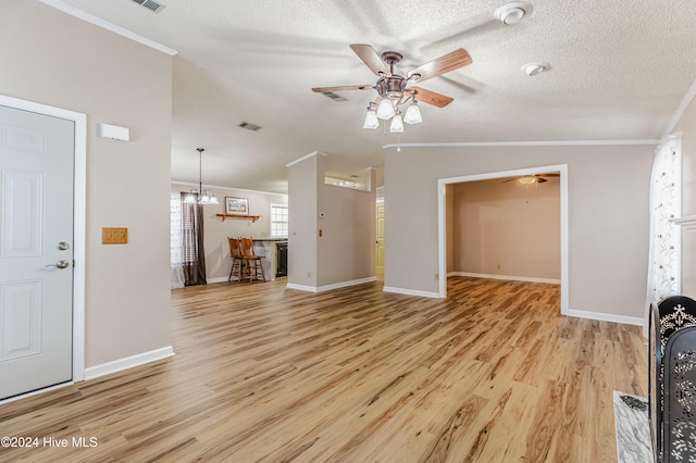 unfurnished living room with a textured ceiling, crown molding, vaulted ceiling, and light wood-type flooring