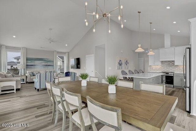 dining space with light wood finished floors, recessed lighting, and high vaulted ceiling