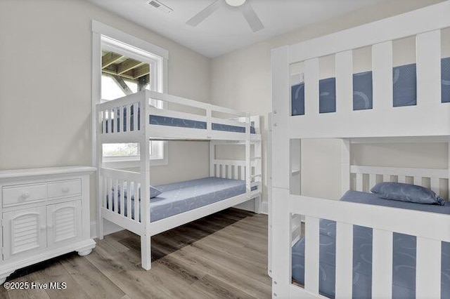 bedroom with visible vents, wood finished floors, and a ceiling fan