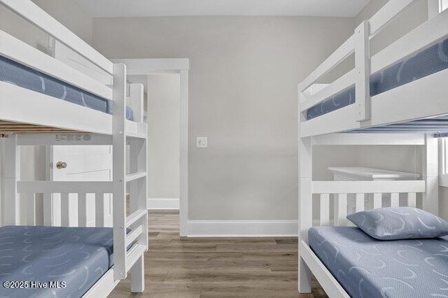 bedroom featuring baseboards and wood finished floors