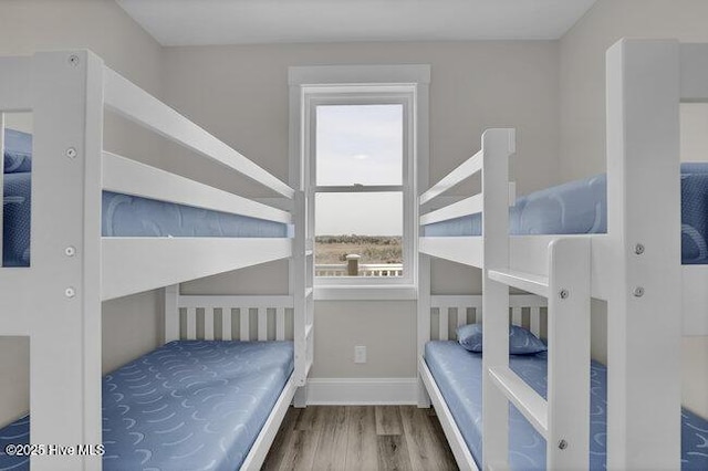 bedroom with wood finished floors and baseboards