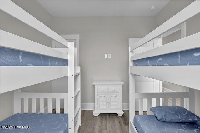 bedroom with baseboards and wood finished floors