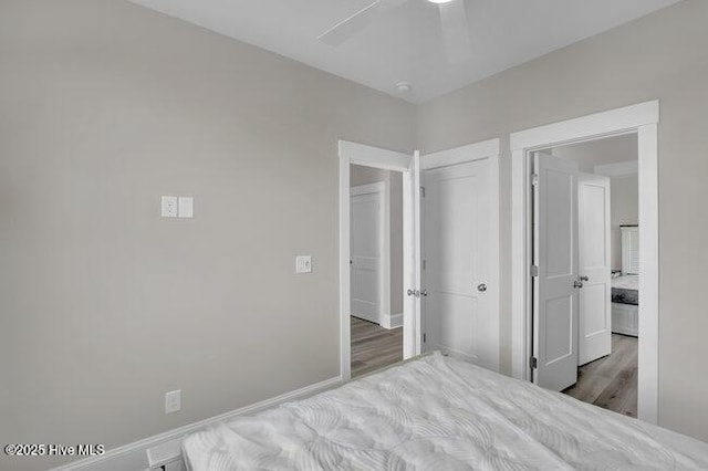 unfurnished bedroom featuring a closet, a ceiling fan, baseboards, and wood finished floors